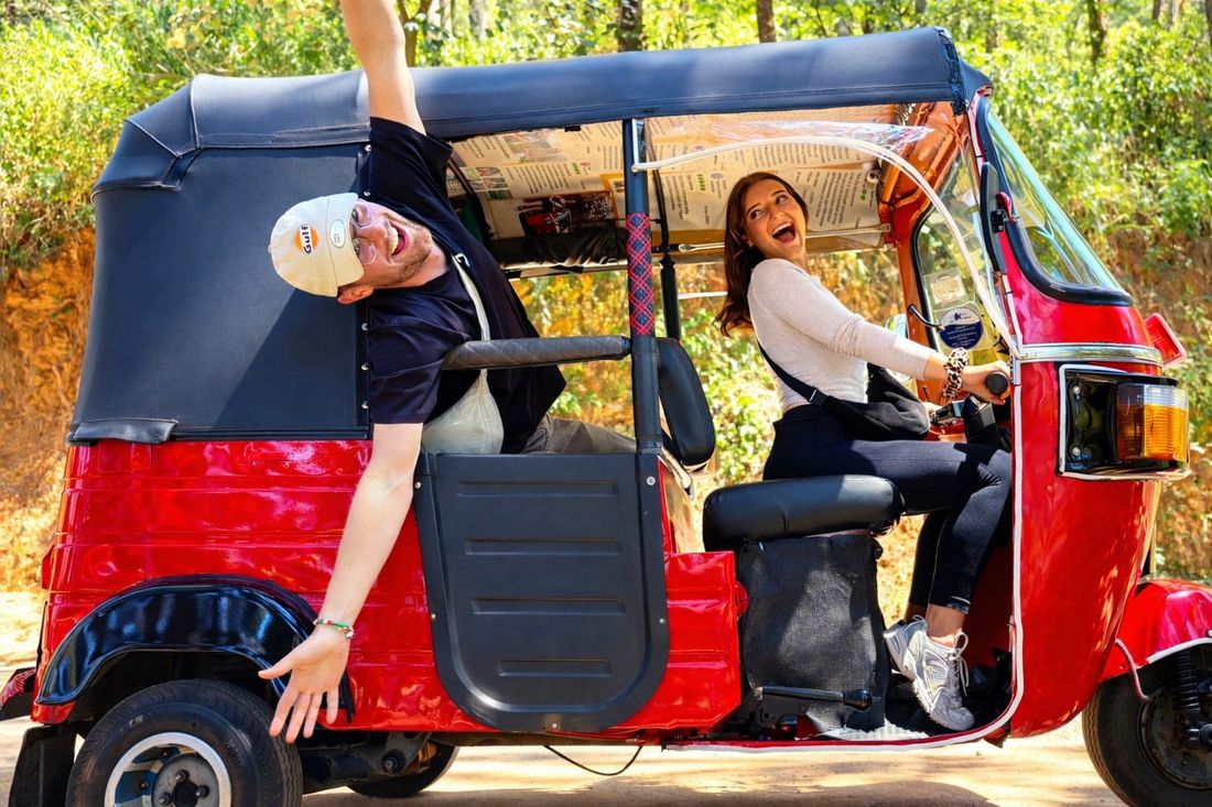 Guests riding through the hills in a red tuk tuk